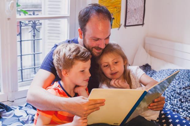 Dad reading to two children