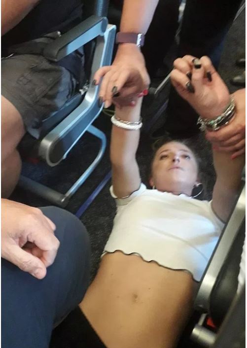 A photo taken on the flight appeared to show a woman on the ground being restrained