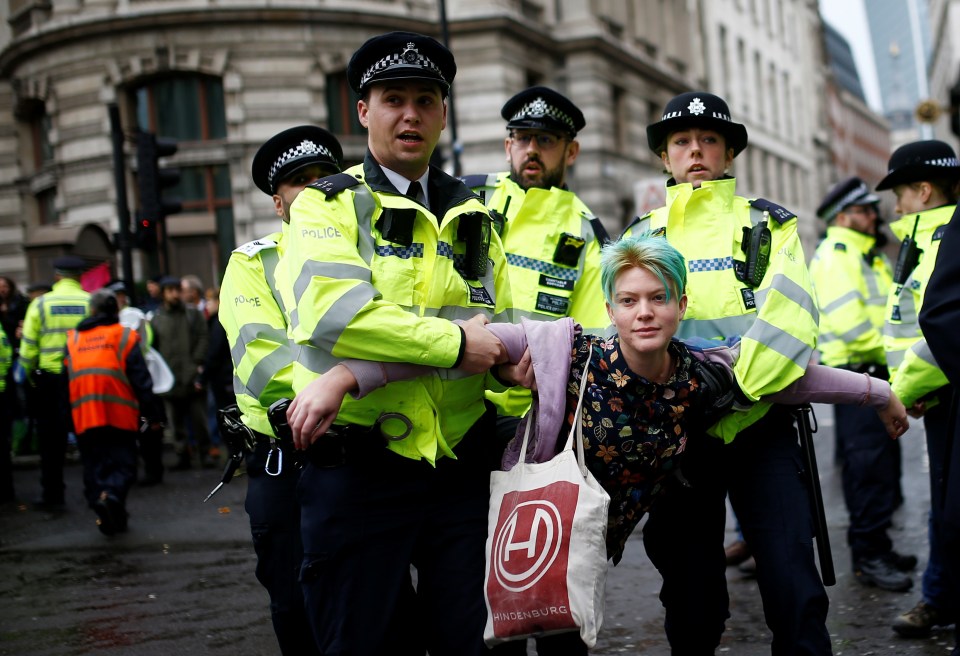  Police officers detain an activist as they block the road during an Extinction Rebellion demonstration at Bank last month