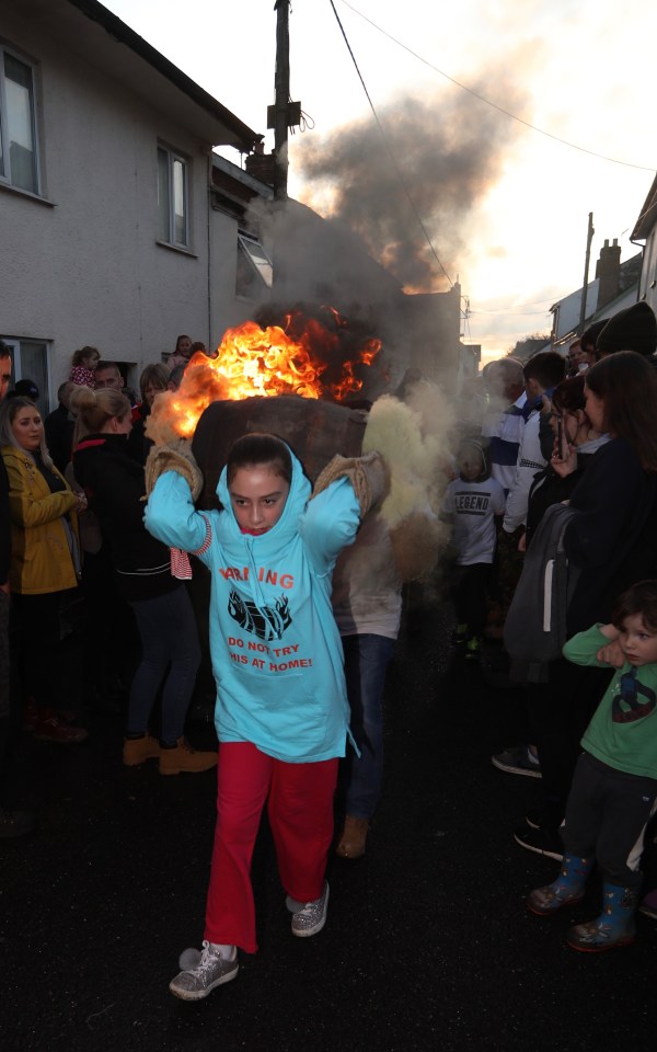  A little girl is seen carrying a tar barrel in Devon