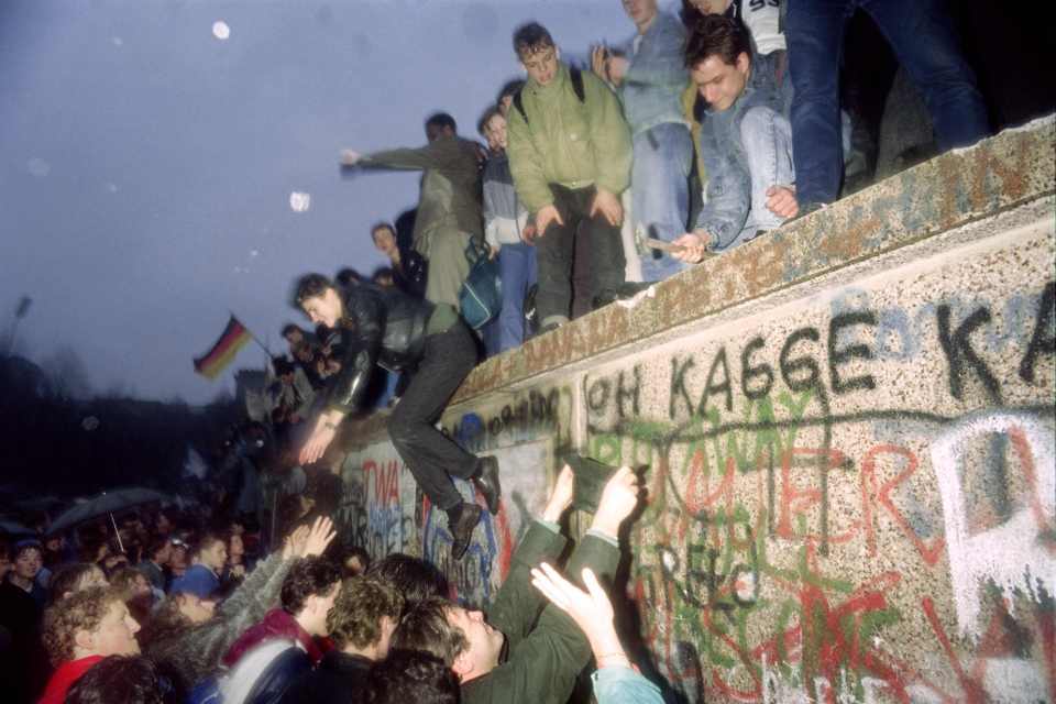  East Germans climb over the wall in November 1989