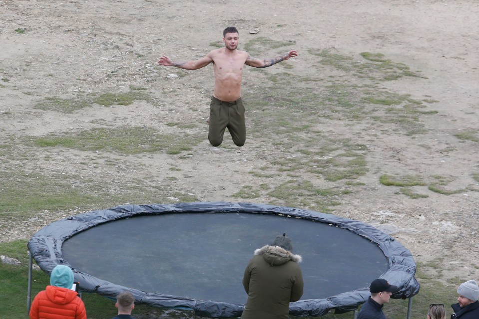  Liam Payne bounces on a trampoline as he braved the cold to go topless for his new music video