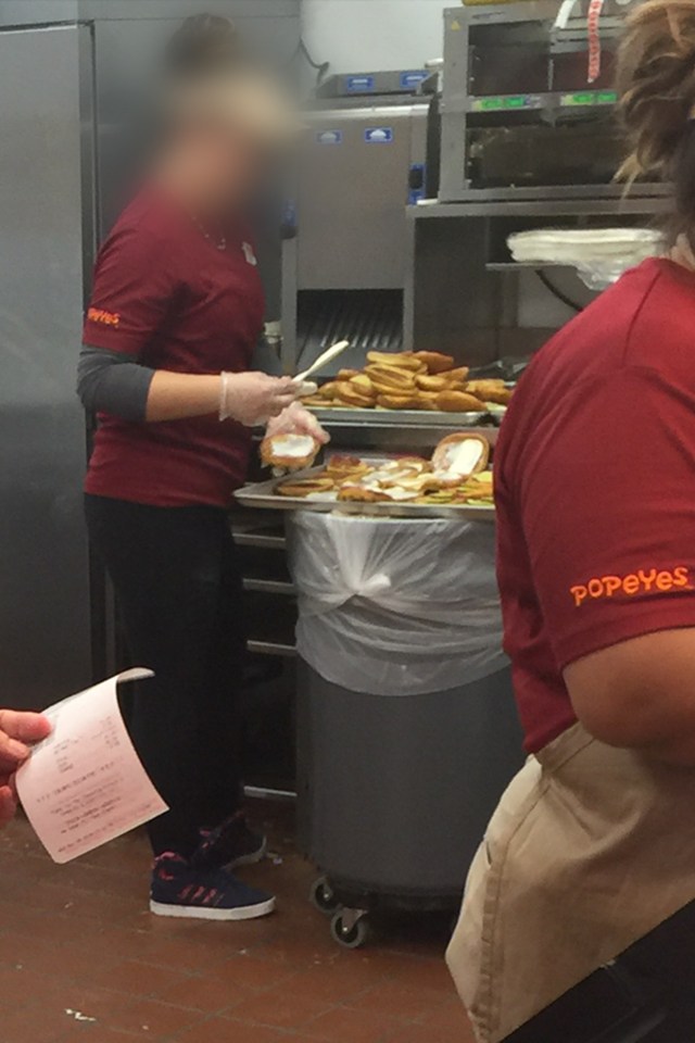  The Popeye's worker was seen making the chicken sandwiches on top of a trash can