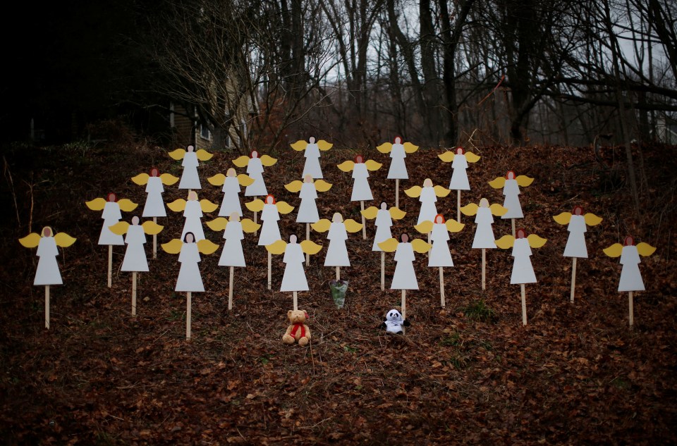  Twenty-seven wooden angel figures are seen placed in a wooded area beside a road near the Sandy Hook Elementary School for the victims of a school shooting