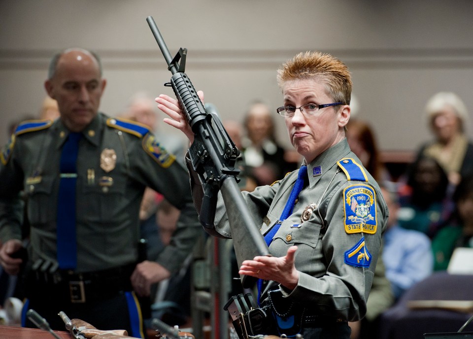  Detective Barbara J. Mattson, of the Connecticut State Police, holds up a Bushmaster AR-15 rifle, the same make and model of gun used by Adam Lanza in the Sandy Hook School shooting