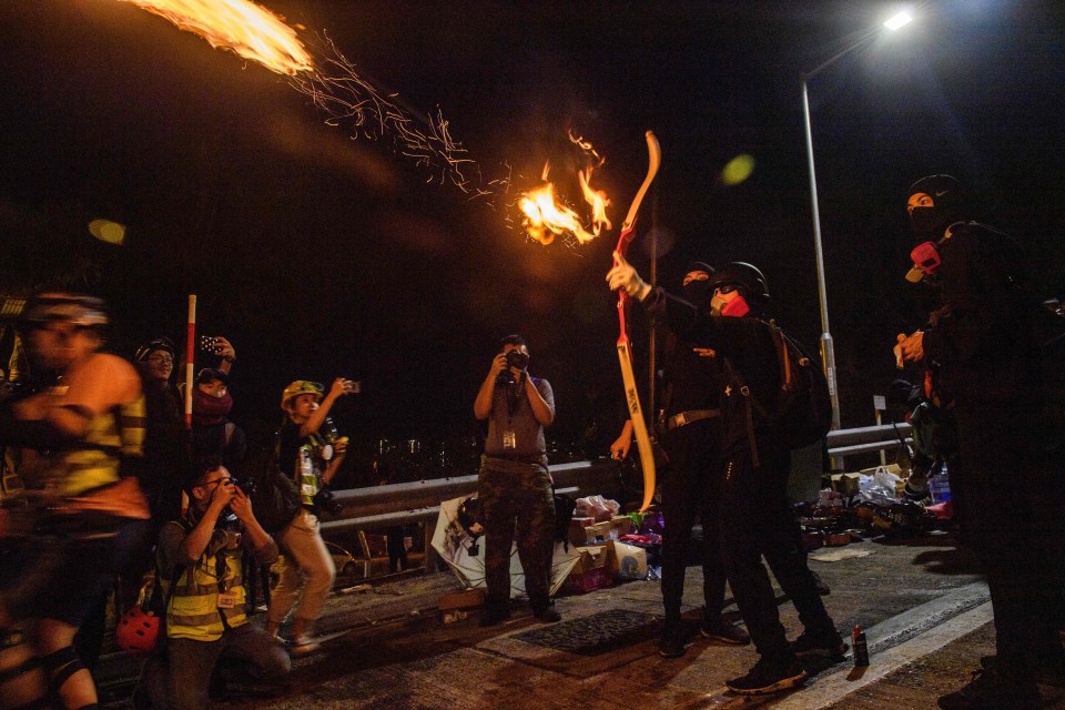 A protester fires a flaming arrow at the Chinese University of Hong Kong amid violent clashes