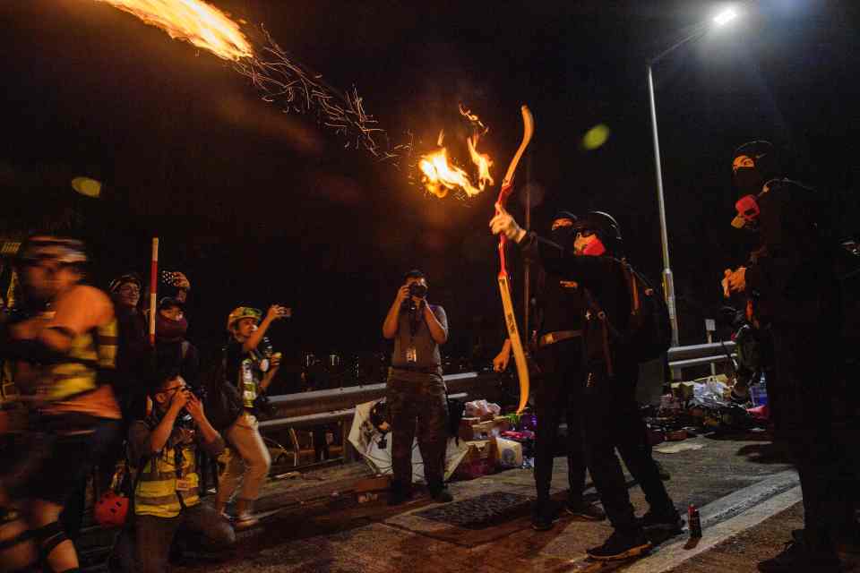  A protester fires a flaming arrow at the Chinese University of Hong Kong amid violent clashes