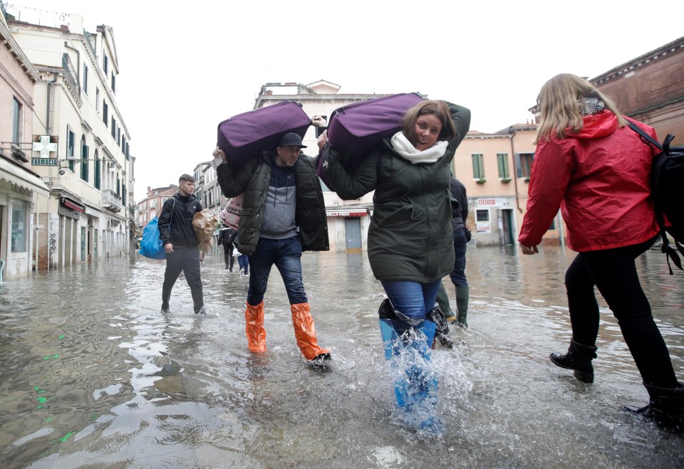  Tourists were forced to carry their luggage through the floodwater