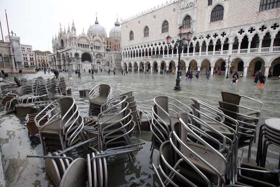  Cafe chairs are piled up in a flooded St. Mark's Square