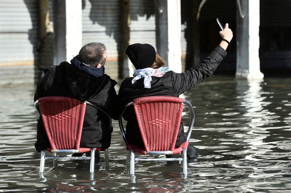  A couple pose for a selfie amid the devastating flooding