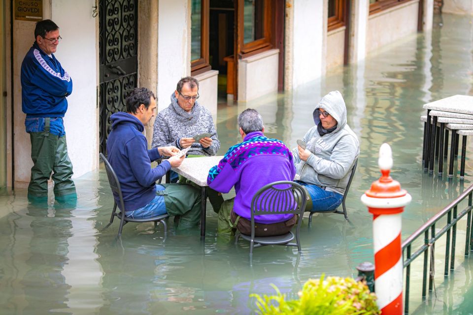  Venice floods 2019: Residents try to ignore the flood and enjoy a card game in the water-filled street