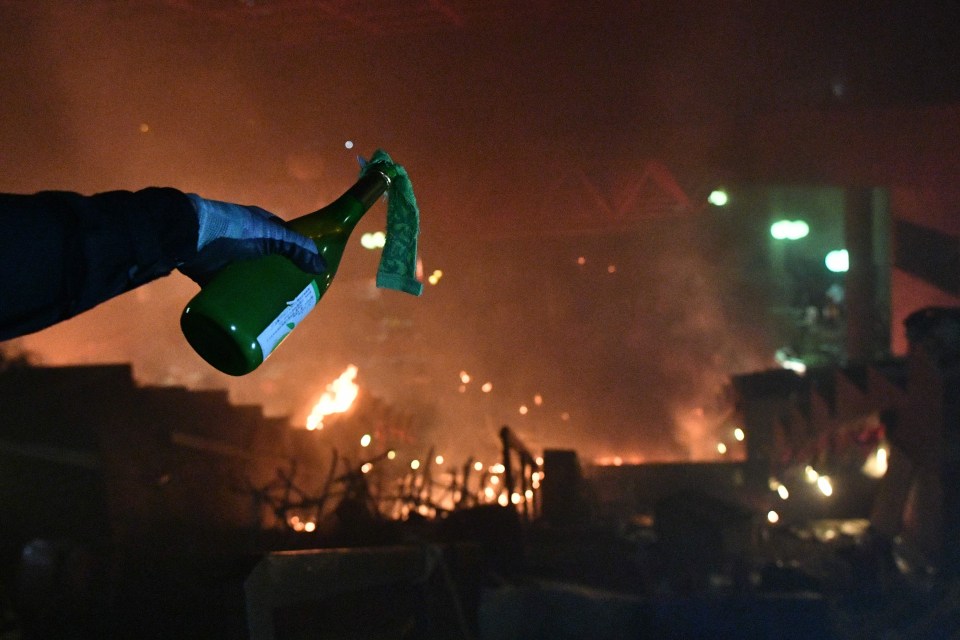 A protester chucks a Molotov cocktail in the direction of riot cops