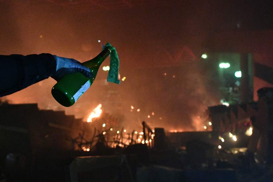  A protester chucks a Molotov cocktail in the direction of riot cops