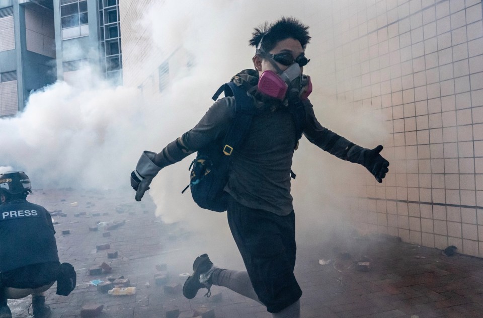 An activist flees the tear gas as tensions continue to escalate