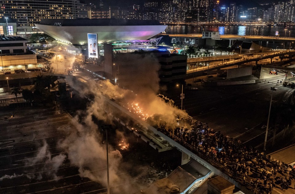 Protesters and riot police clash on a bridge at Hong Kong Polytechnic University on Sunday night