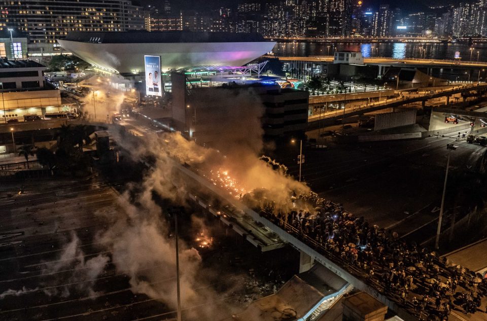  Protesters and riot police clash on a bridge at Hong Kong Polytechnic University on Sunday night