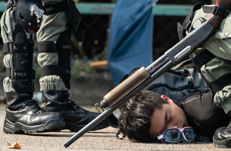 A protester is detained by police as he tries to escape from the university today