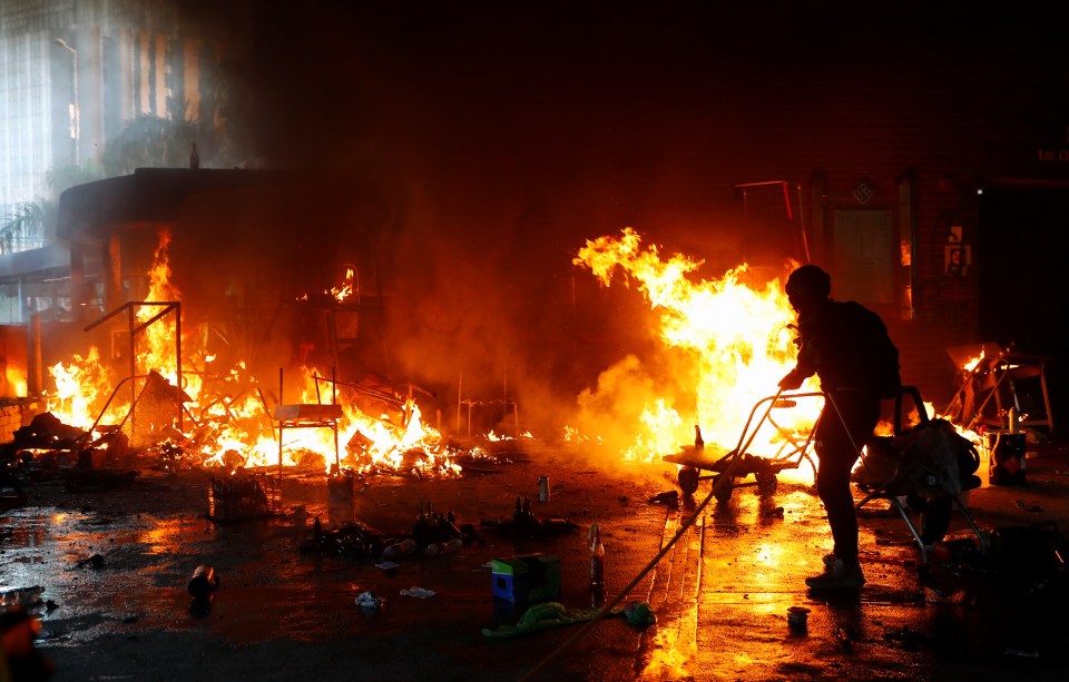 A protester attempts to extinguish a fire at the campus of Hong Kong Polytechnic University