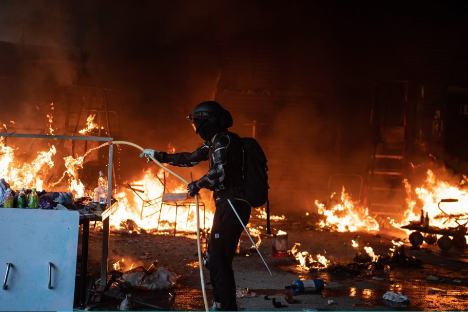 An anti-government protester puts out a fire at Hong Kong Polytechnic