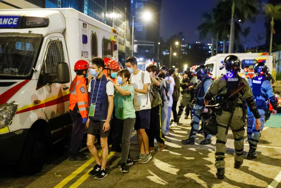 Activists are escorted by police out of the campus of Hong Kong Polytechnic University