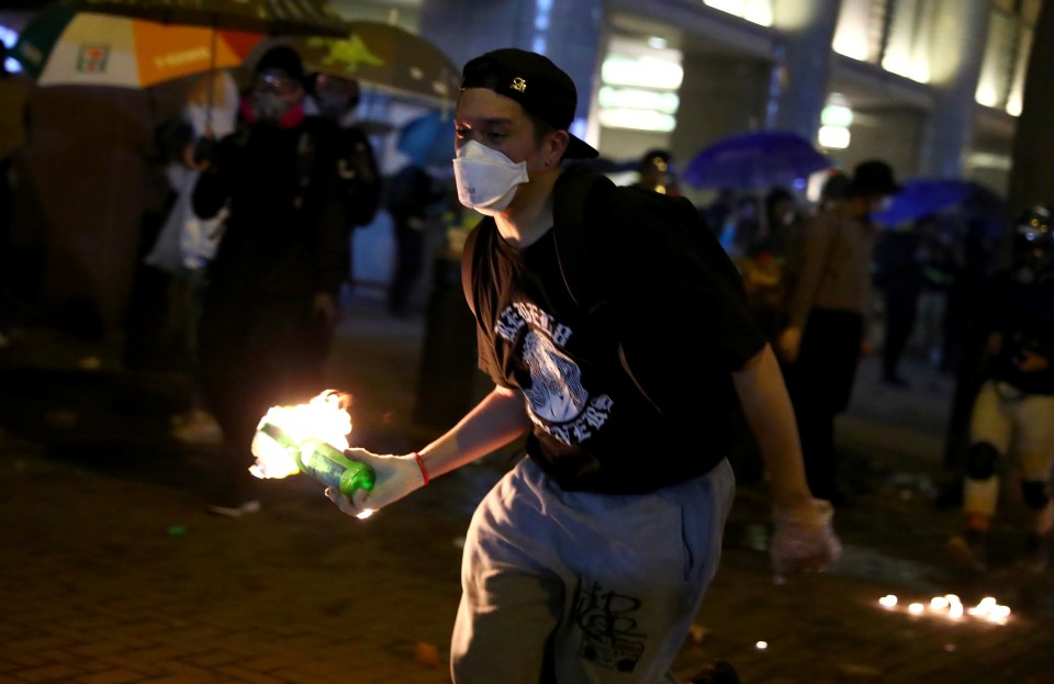  An anti-government demonstrator carries a molotov cocktail during protests at Tsim Sha Tsui, in Hong Kong