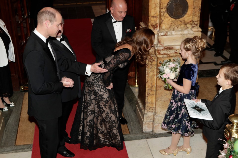  The Duchess kneels as she greets a young girl at the Royal Variety Performance