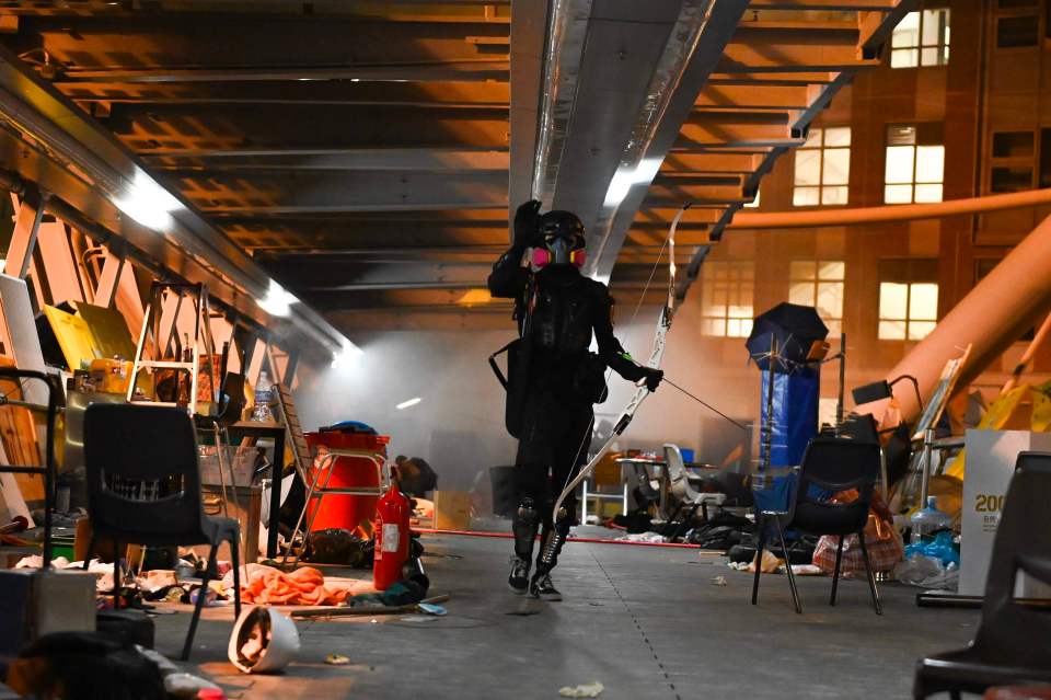  An anti-government protester walks with a bow and arrow on a bridge during protests