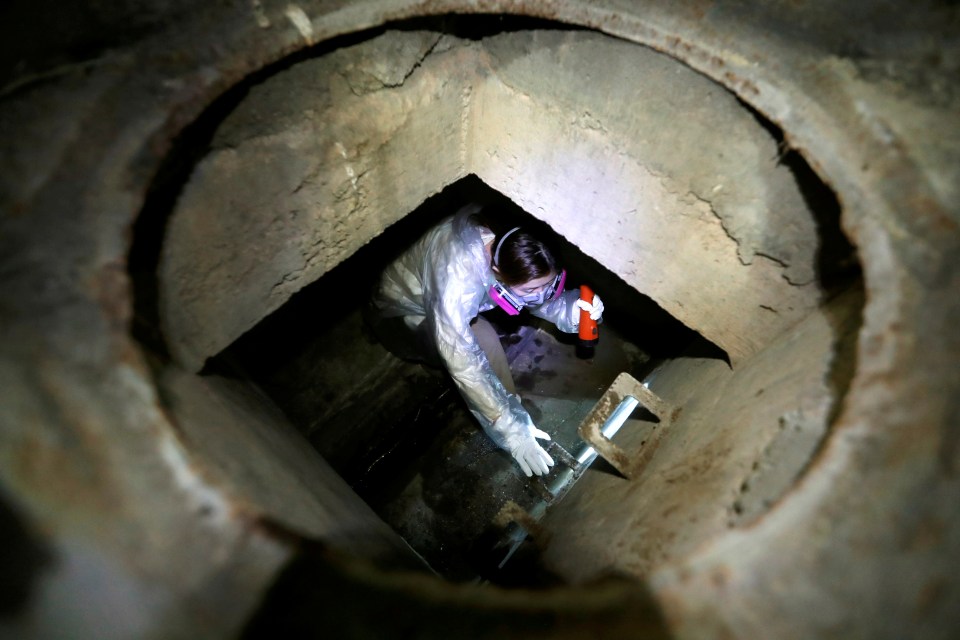  A protester wearing a face mask tries to escape from a sewage tunnel inside the university