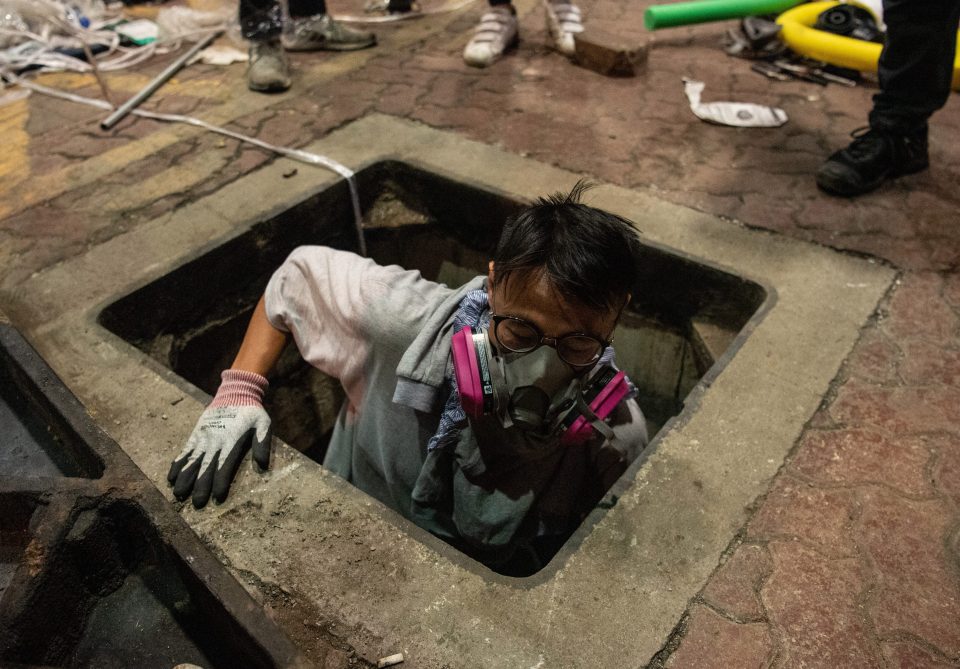  An anti-government protester escapes through a sewer on Tuesday