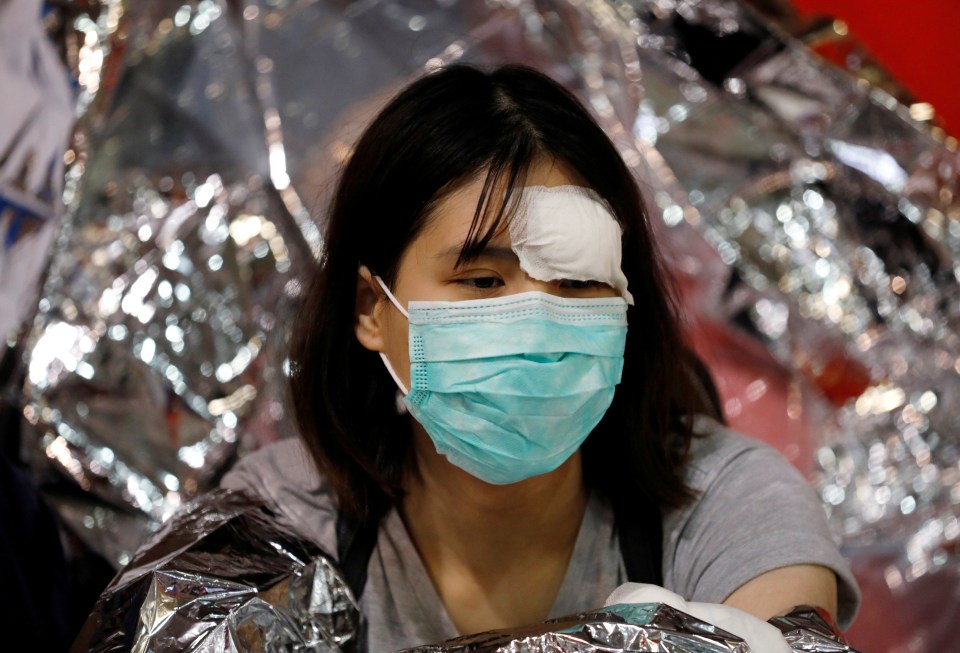  An injured protester waits for medics to take her to the hospital from inside the university