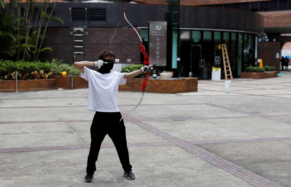  A protester practises shooting with bow and arrow at the besieged Hong Kong Polytechnic University