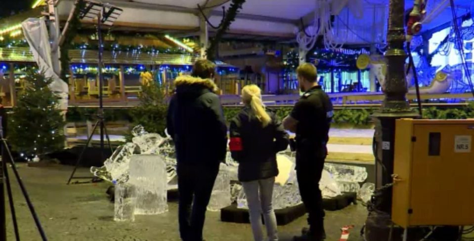  Members of the public stand around the fallen sculpture, close to the ice skating rink