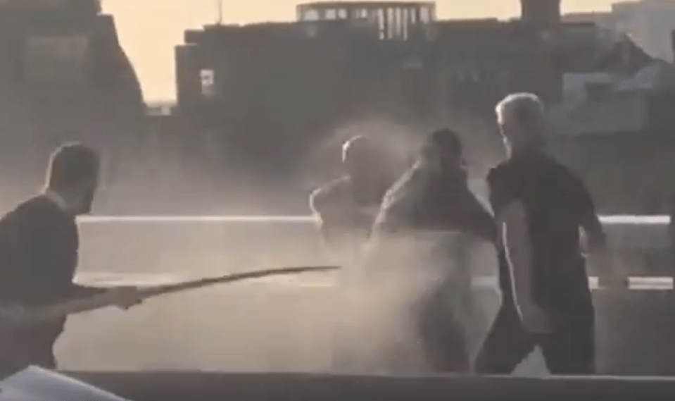  One man brandishes a 6ft long whale tusk and hurtles toward the attacker while another man wrestles him to the ground and a third sprays him with jets from a fire extinguisher on London Bridge