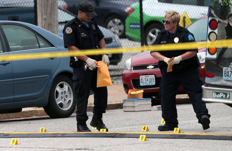 Crime scene investigators with evidence bagging evidence after a man was allegedly shot by a police officer