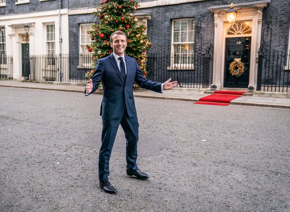  Macron gestures to the media while outside 10 Downing Street in the capital