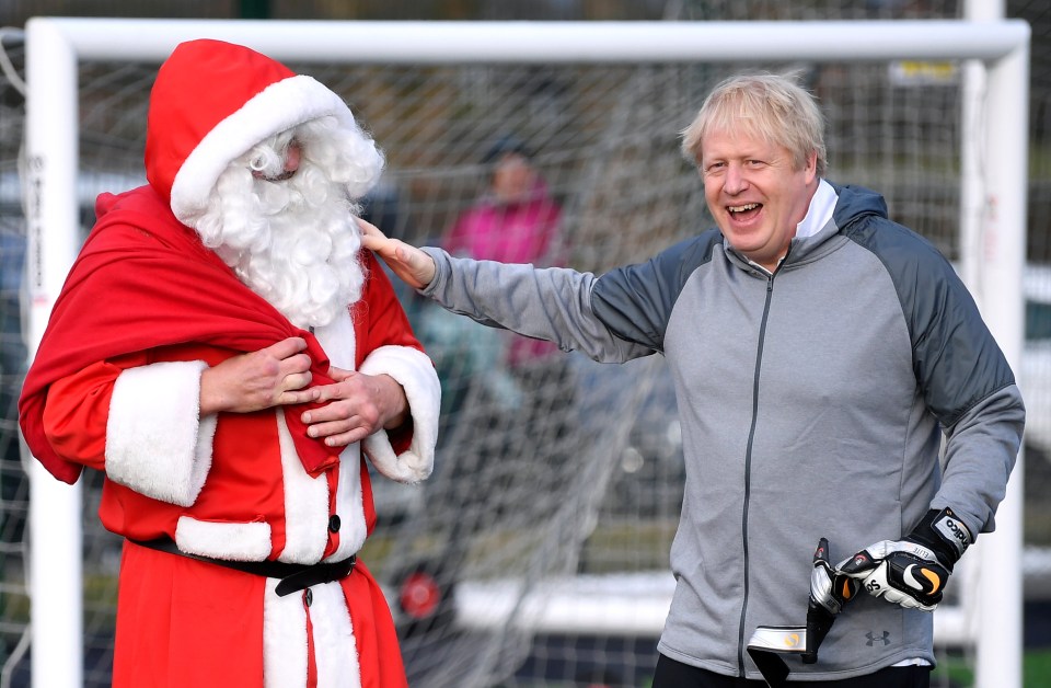  Britain's Prime Minister Boris Johnson greets a man dressed as Santa Claus during election campaign