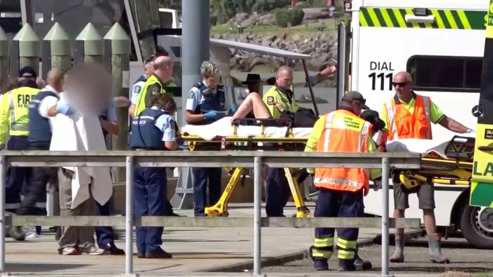  An injured person is wheeled onto an ambulance in the town of Whakatane on New Zealand's North Island