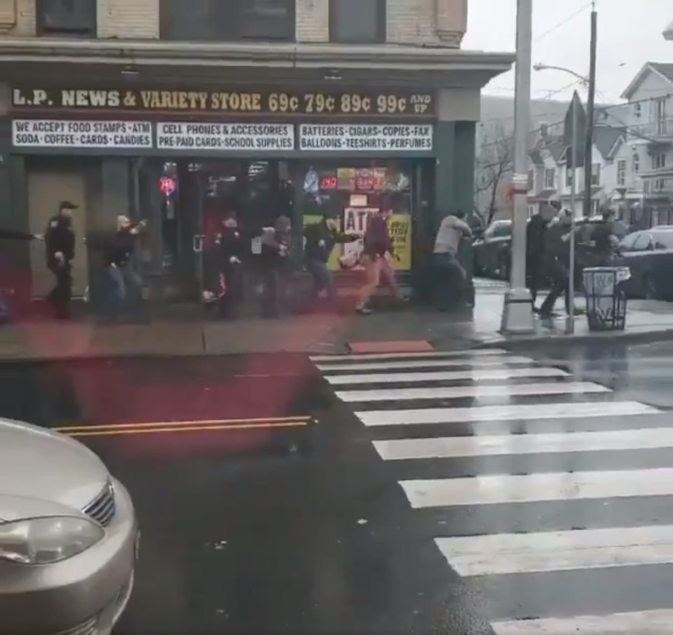  People and police take shelter after the gunmen apparently shot at random from a shop