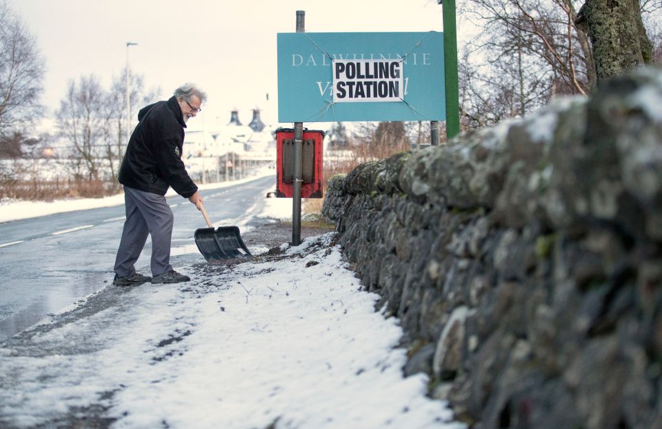  A man clears snow outside the Polling Station at the village hall in Dalwhinnie in the Cairngorms in the Highlands of Scotland