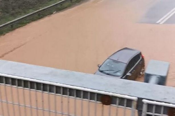  A car attempts to navigate the flooded A30