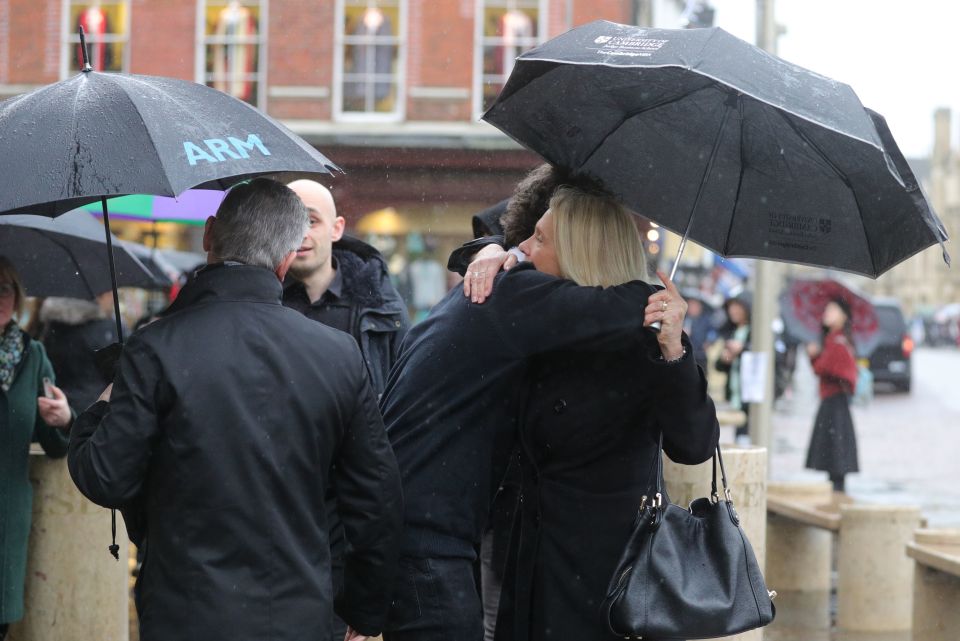  Mourners at Jack Merritt's funeral service embrace outside the church in central Cambridge