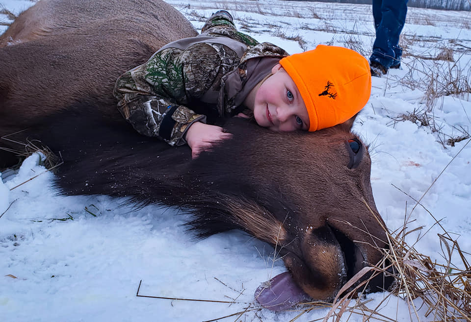 Shocking pictures show eight-year-old Braeleigh Miller lying on the body of a 30-stone elk she shot dead