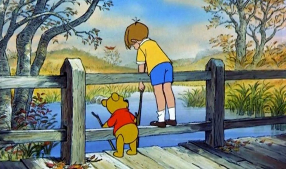  Pooh and Christopher Robin play the fun game on the bridge together