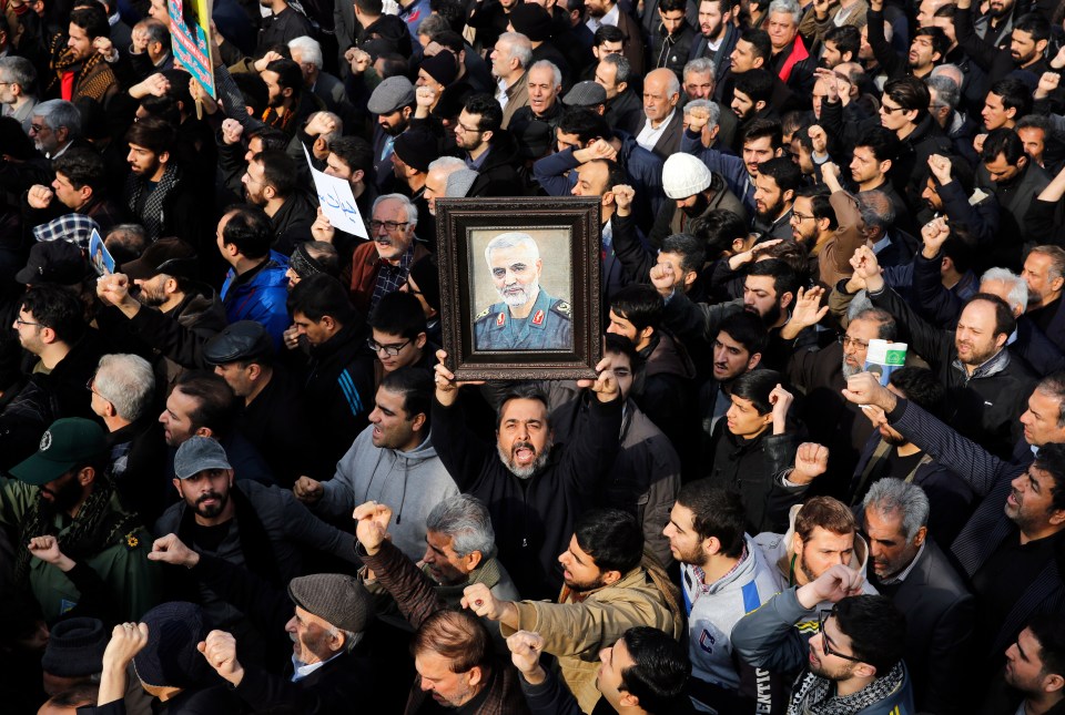 One supporter holds a picture of Soleimani