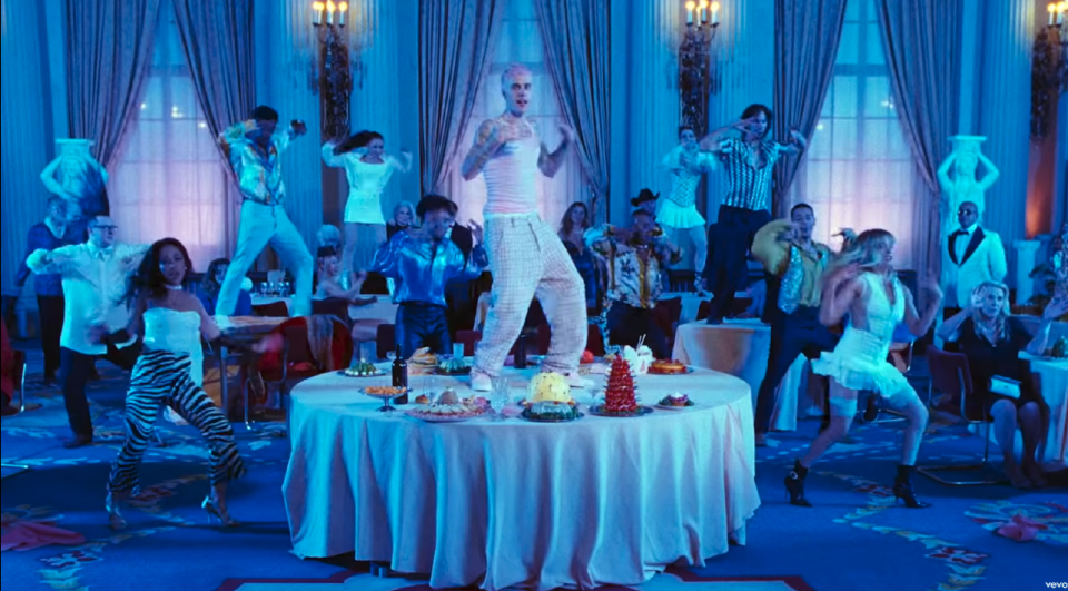  The 25-year-old dances with his pink hair and pink shirt on a dining room table