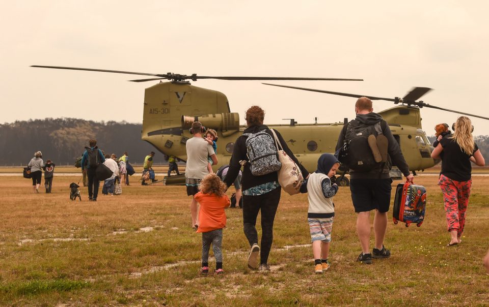 Families with small children and babies are evacuated by air from Mallacoota Airport on January 5, 2020 in Mallacoota, Australia.