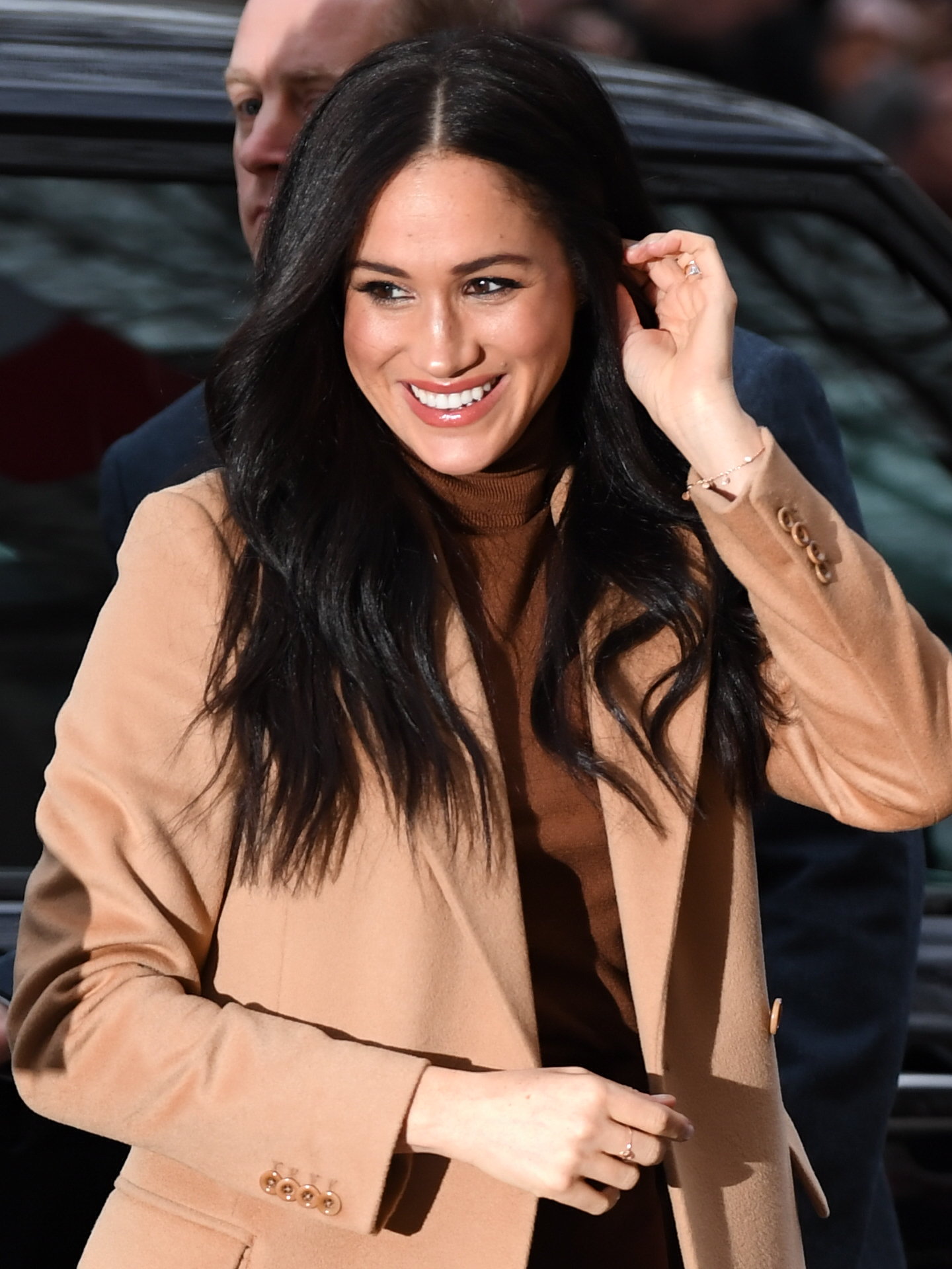 Meghan looks radiant in a brown turtle-neck top and simple jewellery