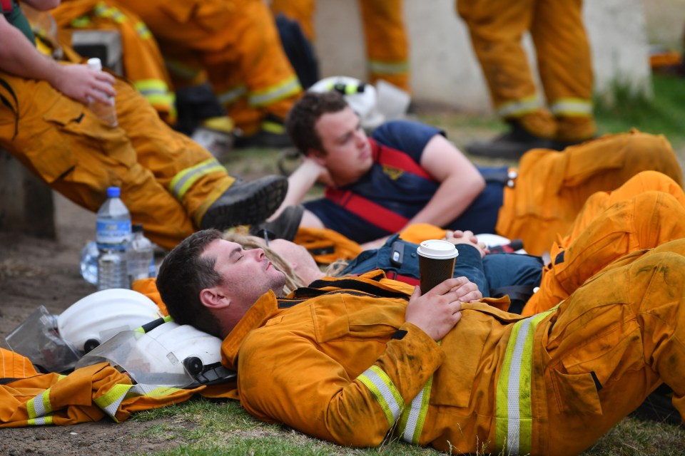  Firefighters rest at Kingscote oval after fighting fires through the night on Kangaroo Island