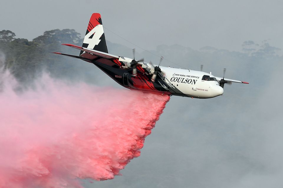  A plane drops fire retardant to protect a property in New South Wales