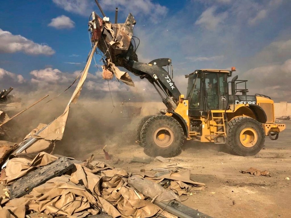 A bulldozer clears rubble and debris at Ain al-Asad air base in Anbar, Iraq